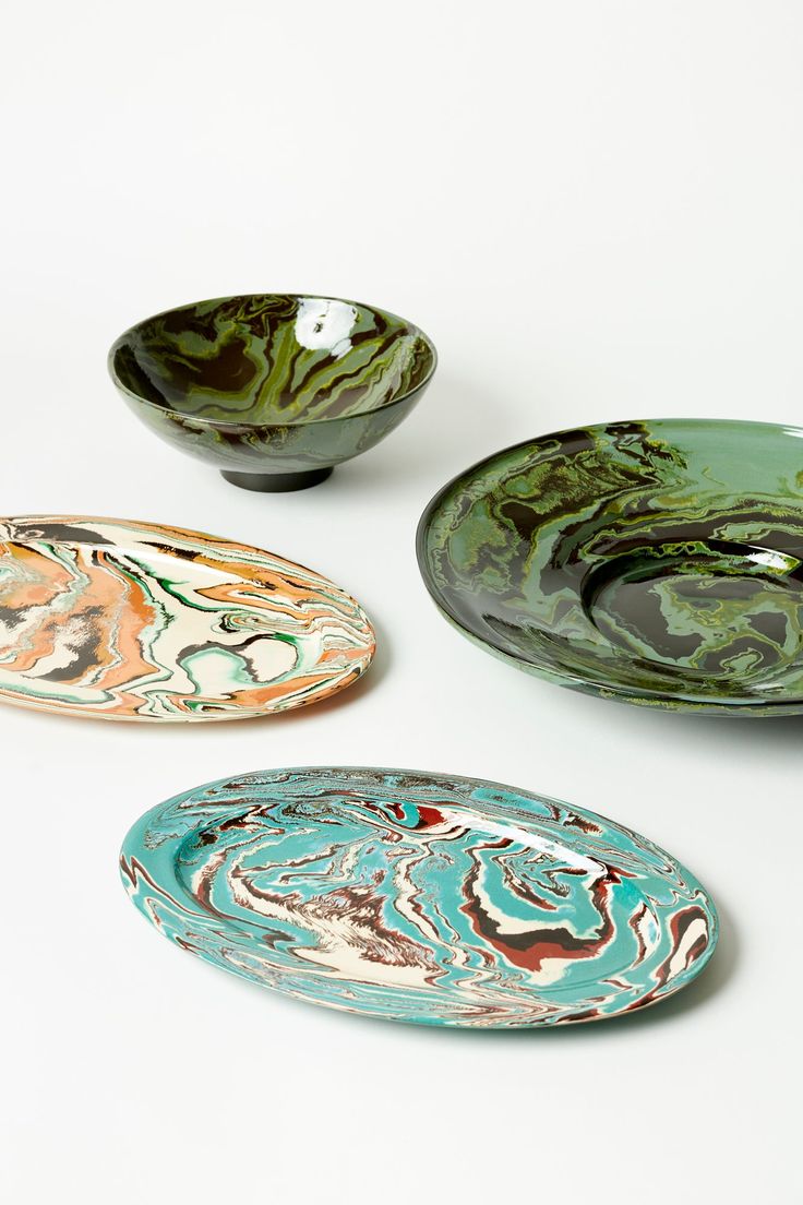 three bowls with different designs on them sitting next to each other in front of a white background