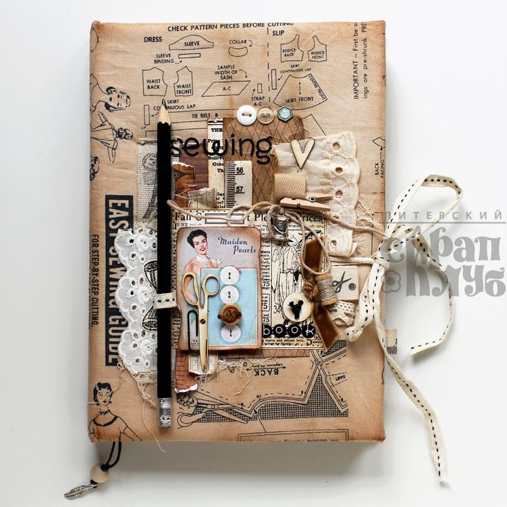 an altered book with scissors and other things on it's cover that is tied to a string