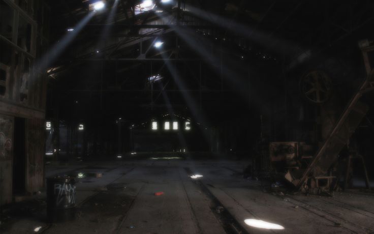 an empty warehouse with beams of light coming from the ceiling and on to the floor