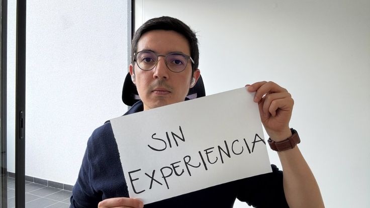 a man holding up a sign that says sin experiencia on it in front of his face