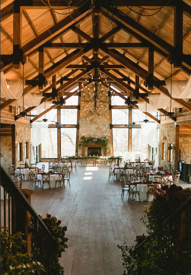 the inside of a large building with tables and chairs set up for an event or function