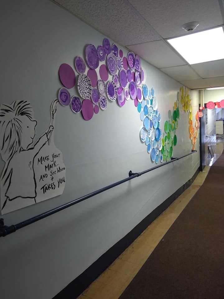 an office hallway decorated with paper plates and magnets