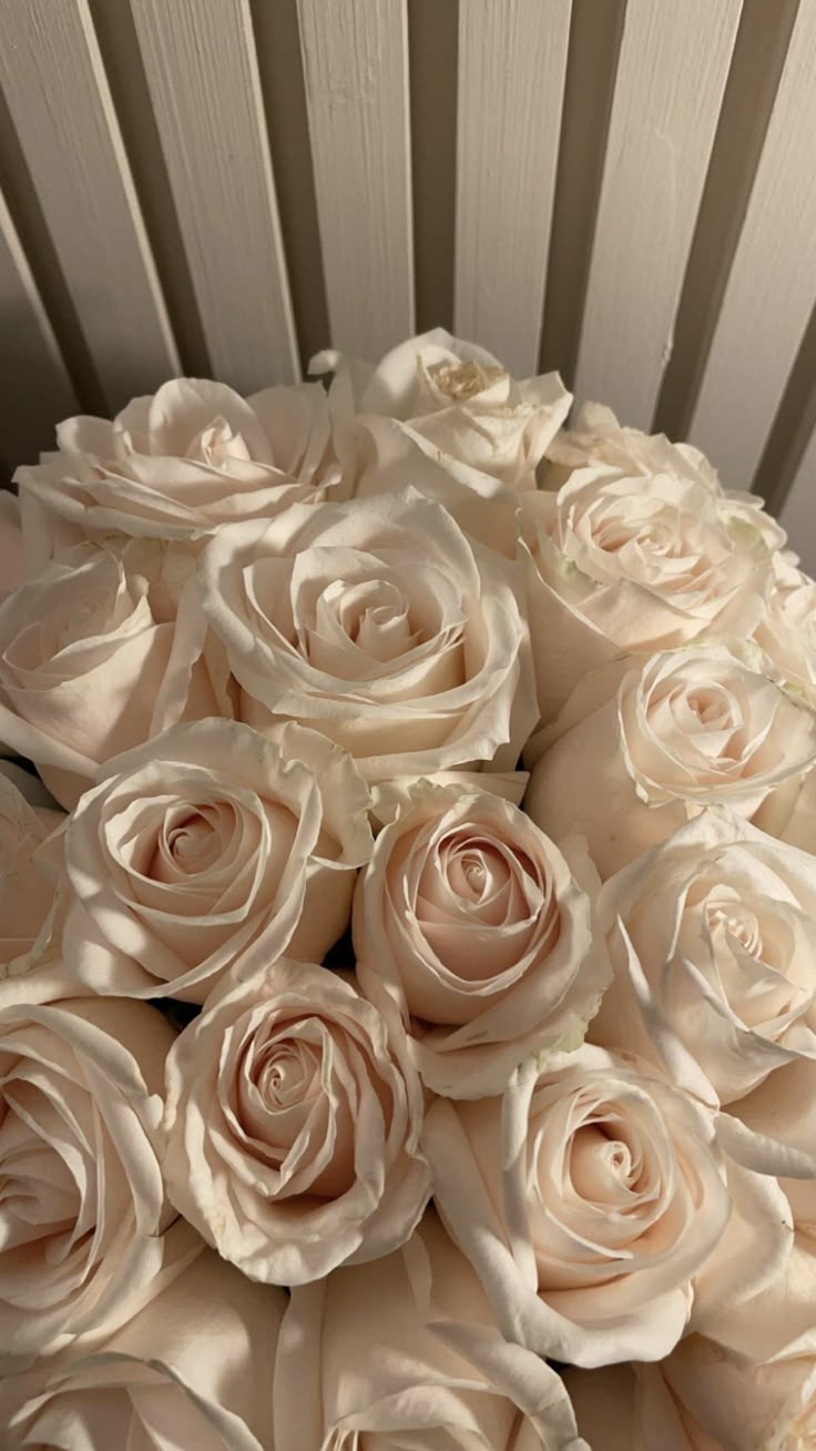 a bouquet of white roses sitting on top of a table