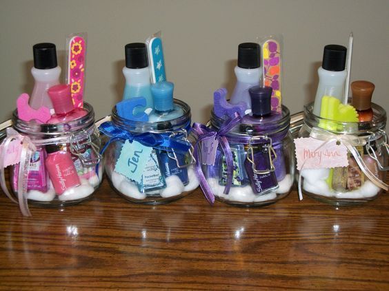 four jars with toothbrushes and other items in them sitting on a wooden table