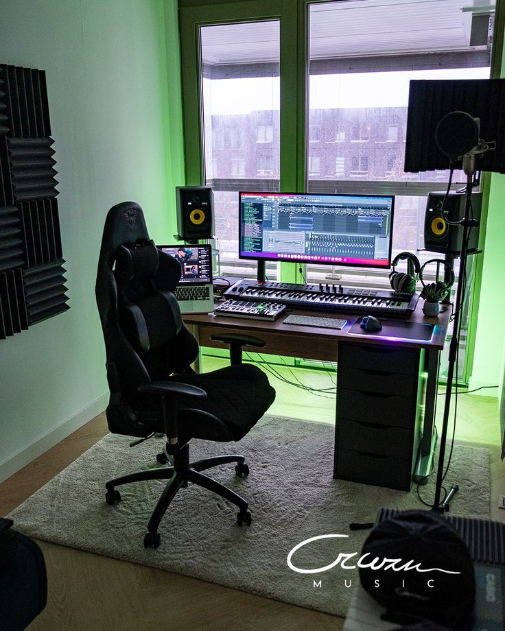 a computer desk with two monitors and headphones on top of it in front of a window