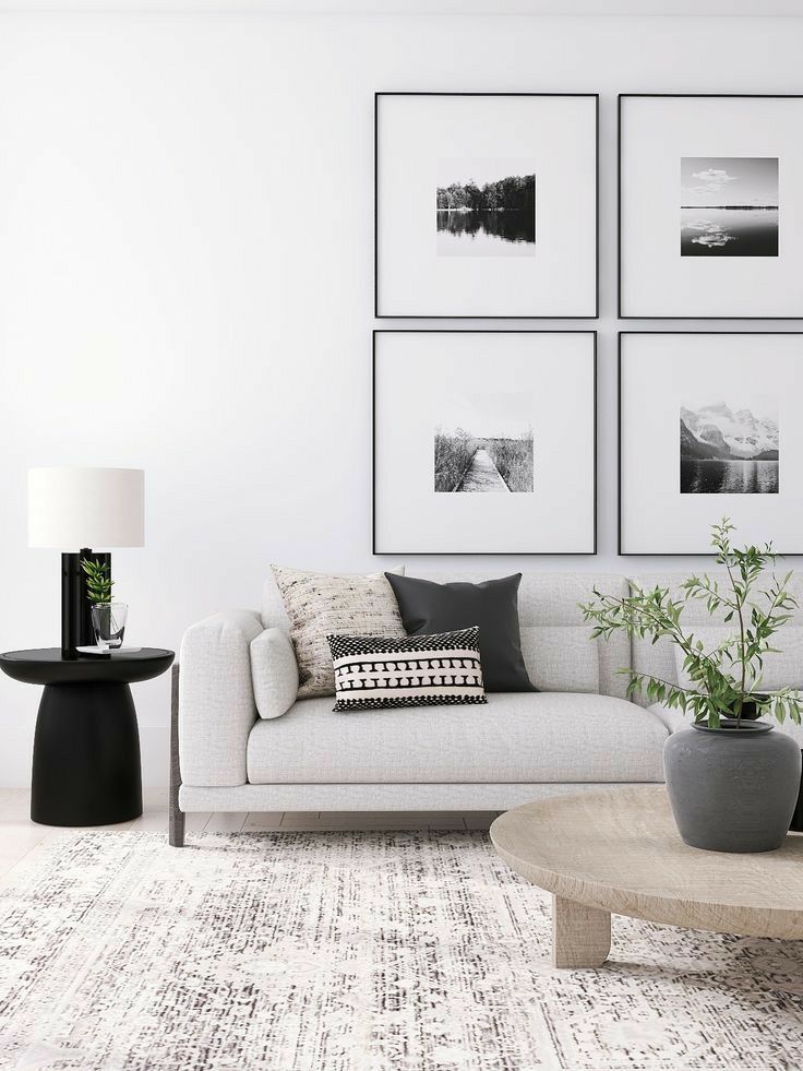 a living room with pictures on the wall and a couch in front of a coffee table