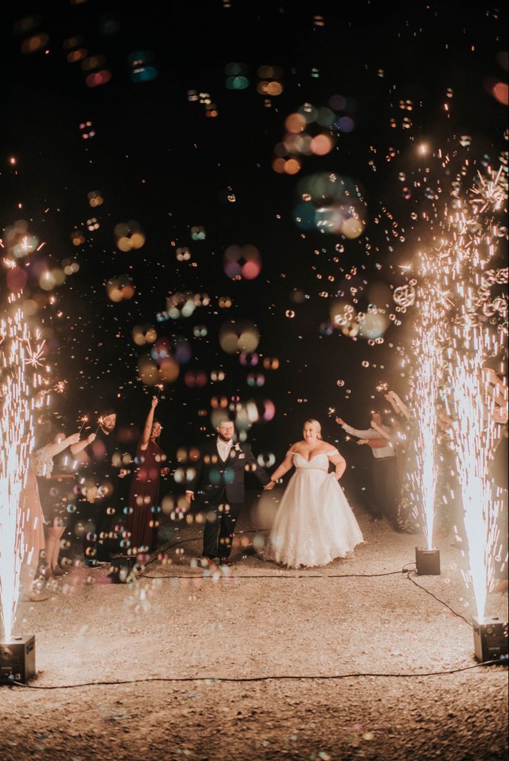 the bride and groom are surrounded by sparklers