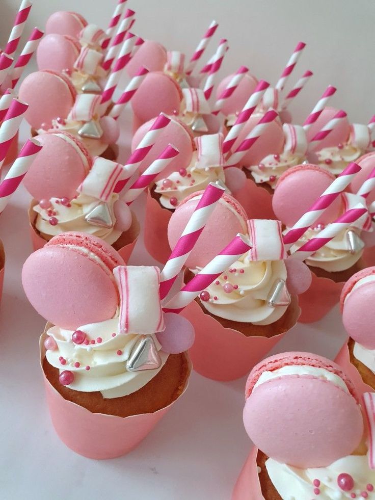 cupcakes with pink and white frosting are lined up