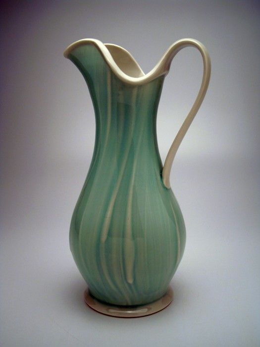 a green and white striped vase on a table