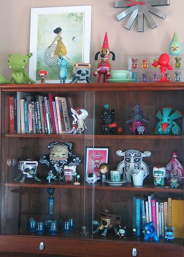 a wooden book shelf filled with figurines on top of it's sides