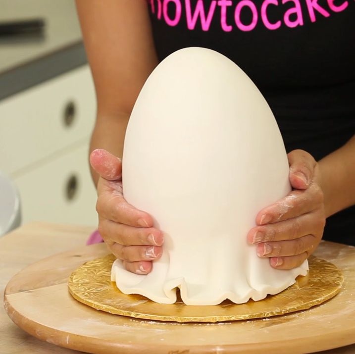 a woman holding an egg on top of a wooden board