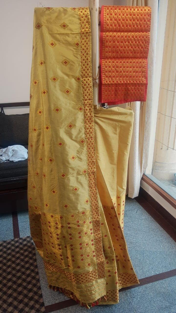 Welcome to our shop, where we take pride in offering you the finest craftsmanship and exquisite textiles. Introducing our pure Muga silk Mekhela Chador, a timeless masterpiece that beautifully combines tradition and elegance. Handwoven with care and precision, this Mekhela Chador is crafted from pure Muga silk, sourced from the silkworm Antheraea assamensis, which is indigenous to Assam, India. Muga silk is known for its lustrous golden hue, unparalleled sheen, and incredible durability. It is c Resham Embroidered Katan Silk Blouse Piece For Puja, Festive Katan Silk Traditional Wear, Handloom Kurta For Traditional Ceremonies And Festivals, Festive Sets In Paithani Silk With Traditional Drape, Traditional Tussar Silk Pre-draped Saree For Navratri, Traditional Pre-draped Saree For Diwali Ceremonies, Pre-draped Saree With Traditional Patterns For Festivals, Traditional Pre-draped Saree For Ceremonies, Diwali Traditional Pre-draped Saree