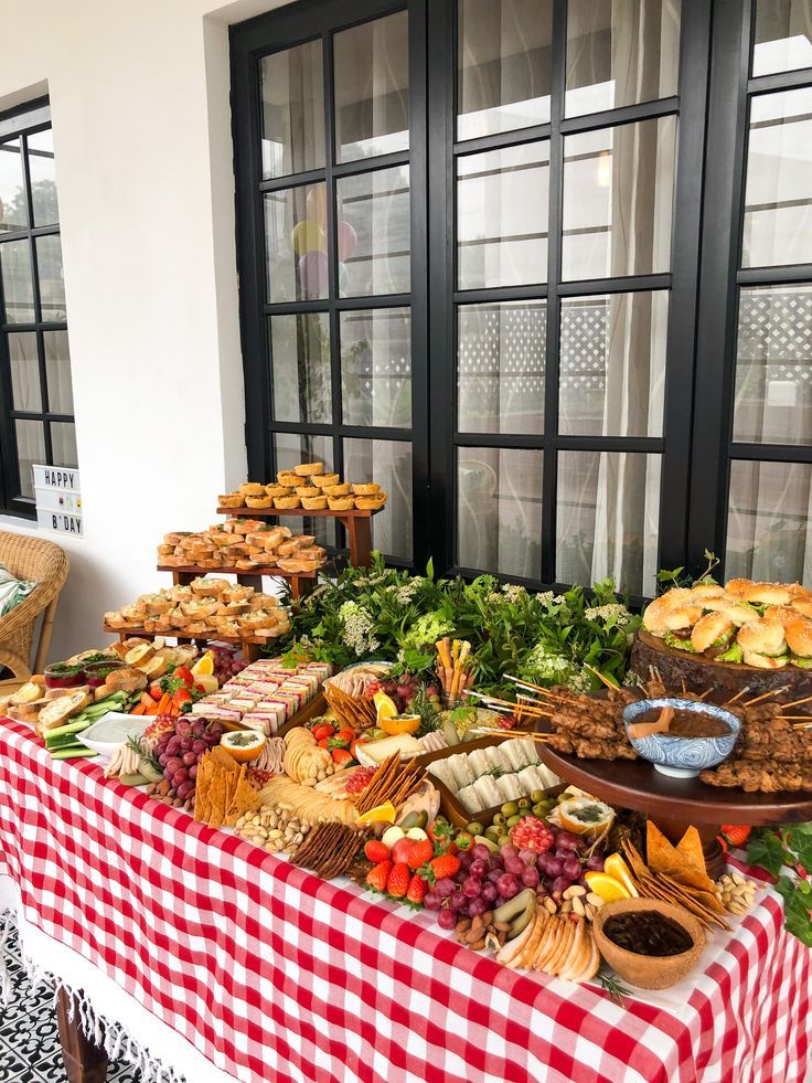 a table with many different foods on it and some windows in the backround