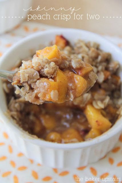 a spoon full of oatmeal with peaches and crumbled topping