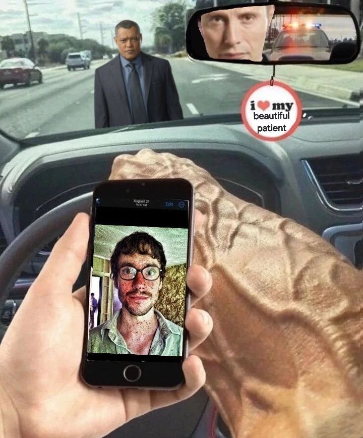 a person holding up a cell phone in front of a car with two men behind them