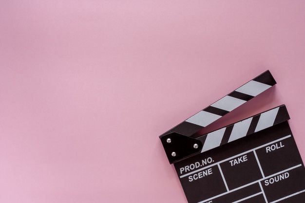 a movie clapper sitting on top of a pink surface