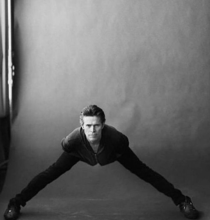 a man is doing a handstand in front of a mirror with his feet on the ground