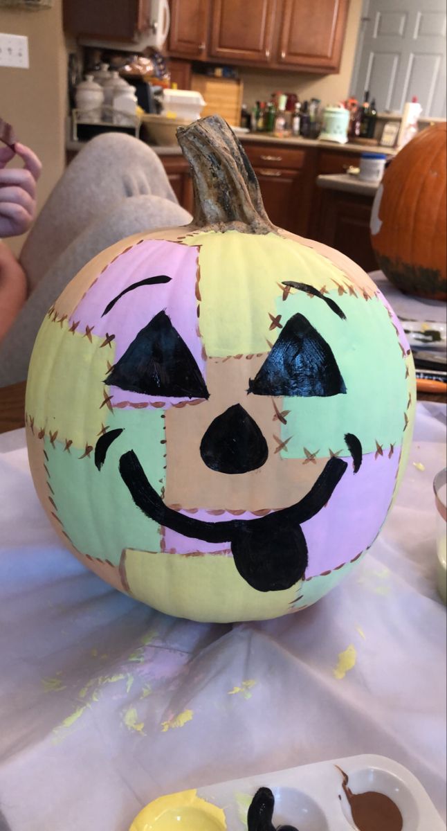 a painted pumpkin sitting on top of a table