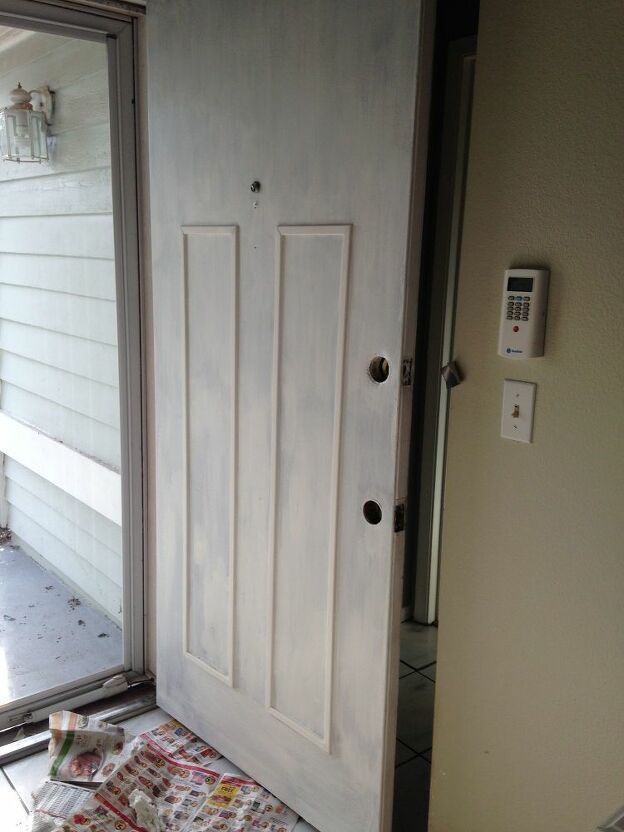 an open door with newspaper on the floor next to it