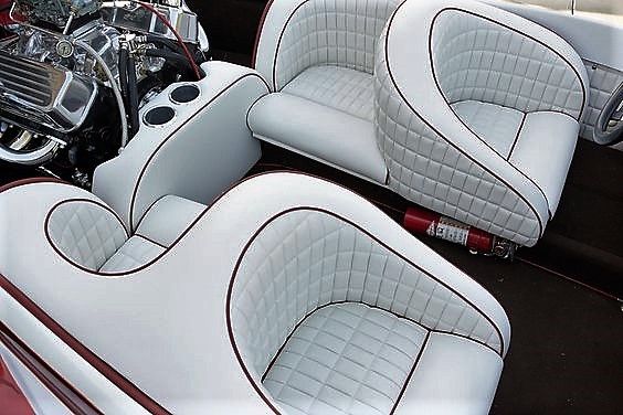 two white and red leather seats in the back of a car with a motorcycle engine