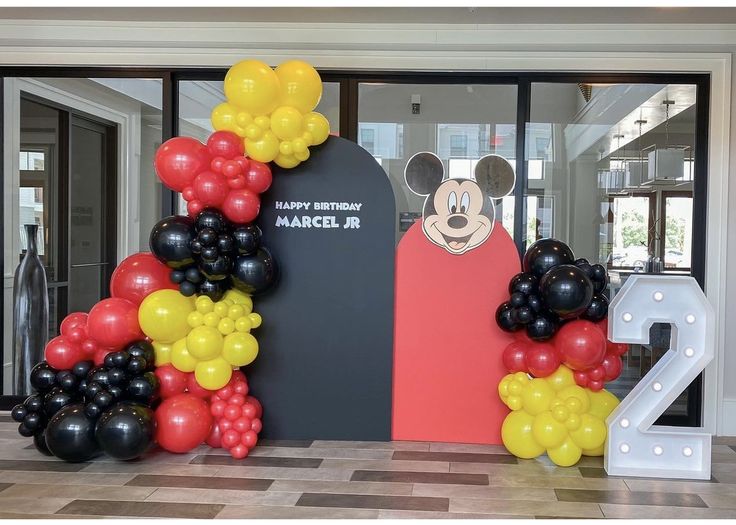 mickey mouse balloon arch at the entrance to an office