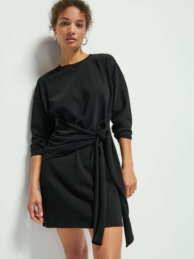 This no-fuss drop-shoulder wrap dress is just what you've been looking for. A relaxed fit crew neck with a contrast neckband, shirring at the waist, and a tie to cinch in as much or as little as you want. Complete the look with your favorite knee-highs and prepare to turn some heads. (This one comes in Jet Black.) | Gloria Dress in Jet Black | Ethical Essentials Luxe Lounge, Nation Ltd, Wrap Front Dress, Knee Highs, Shoulder Wrap, High Knees, Jet Black, You've Been, Drop Shoulder