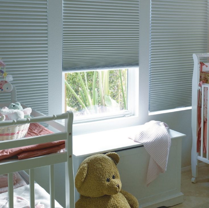 a teddy bear sitting in the corner of a room next to a window with blinds