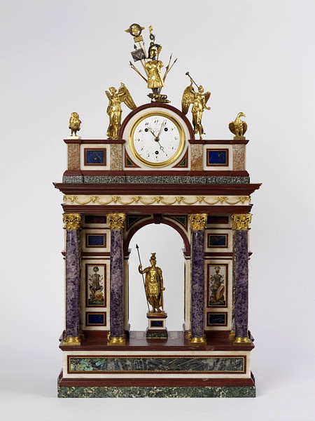 an ornate clock with statues on top of it