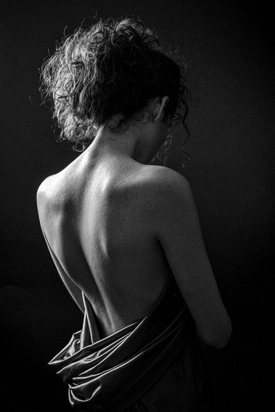 black and white photograph of a woman in a towel looking off into the distance with her back to the camera