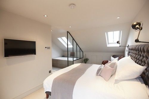 a bedroom with a large bed and tv mounted on the wall