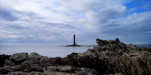 the lighthouse is surrounded by rocks and water