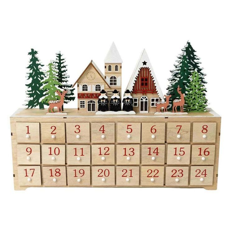 a wooden calendar with houses and trees on it's sides, in front of a white background