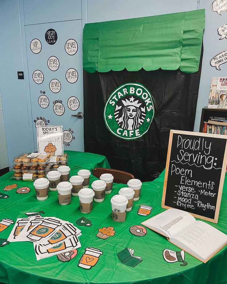 a green table topped with cups of coffee next to a sign that says starbucks cafe