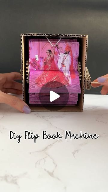 a woman holding up a small box with pictures on it and the words diy flip book machine