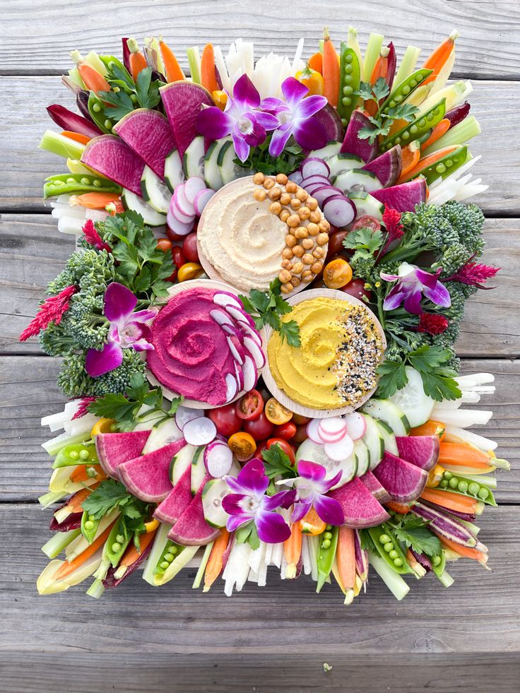 an arrangement of flowers and vegetables arranged in a circle