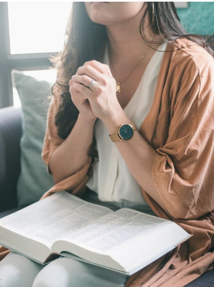 a woman sitting on a couch holding a book