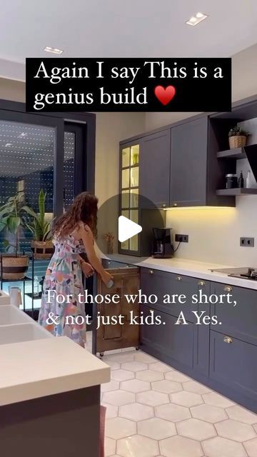 a woman standing in a kitchen next to a window