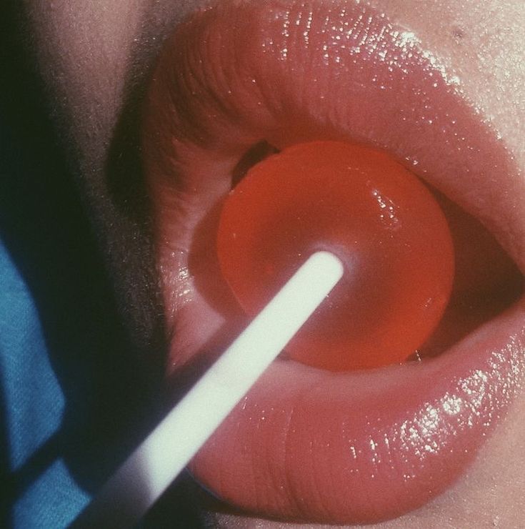 a woman's red lips with a white stick sticking out of the top lip