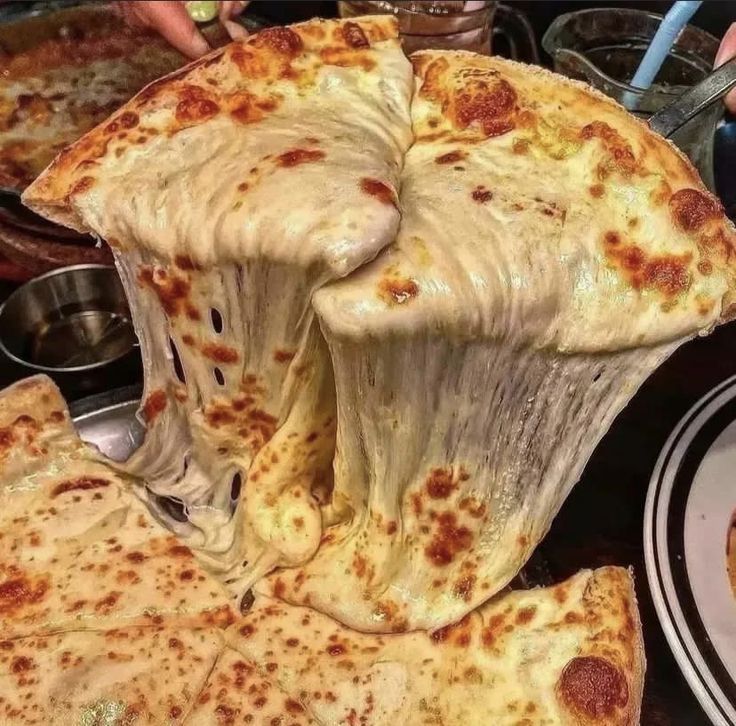 a large pizza sitting on top of a table covered in cheese