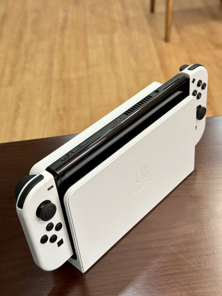 a white nintendo wii console sitting on top of a wooden table