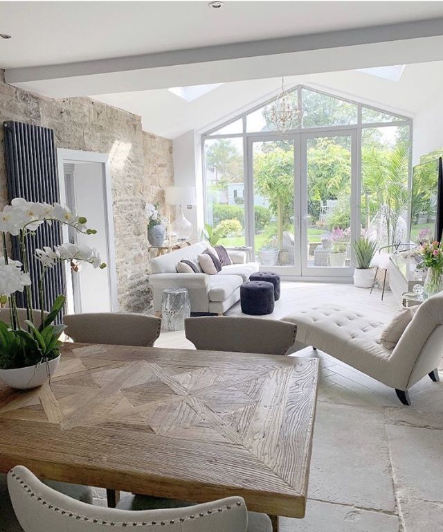 a living room filled with furniture next to a large glass window covered in white flowers