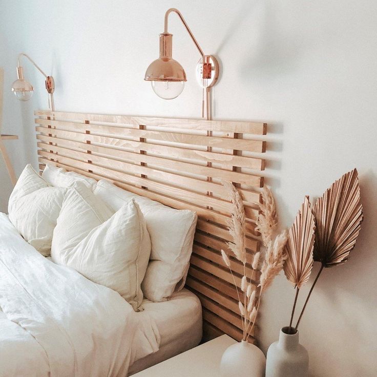 a bed with white sheets and pillows on top of it next to a night stand