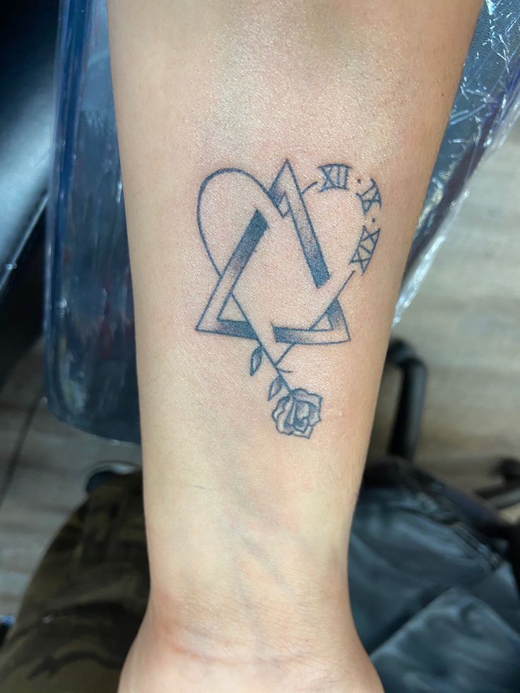 a tattoo on the foot of a woman with an arrow and heart in the middle