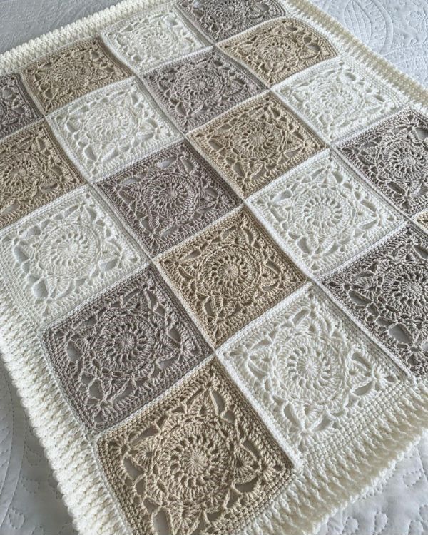 a white crocheted blanket on top of a bed