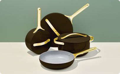 a group of pots and pans sitting on top of a white table next to each other