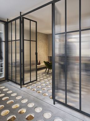 an empty room with glass walls and lots of plates on the floor in front of it