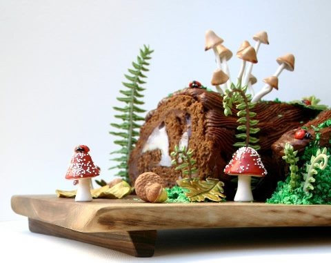 a cake with mushrooms and plants on it