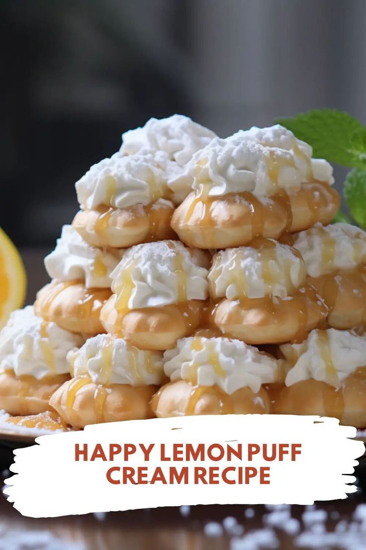 a pile of lemon puff cream cookies sitting on top of a table next to an orange slice