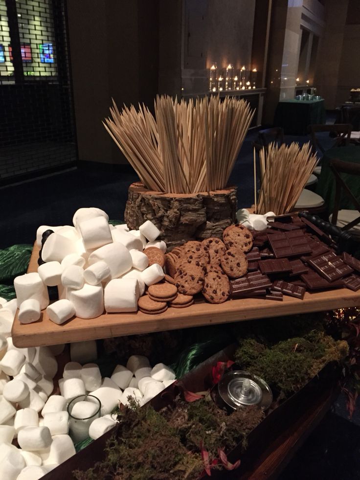 marshmallows, cookies and other treats are arranged on a table