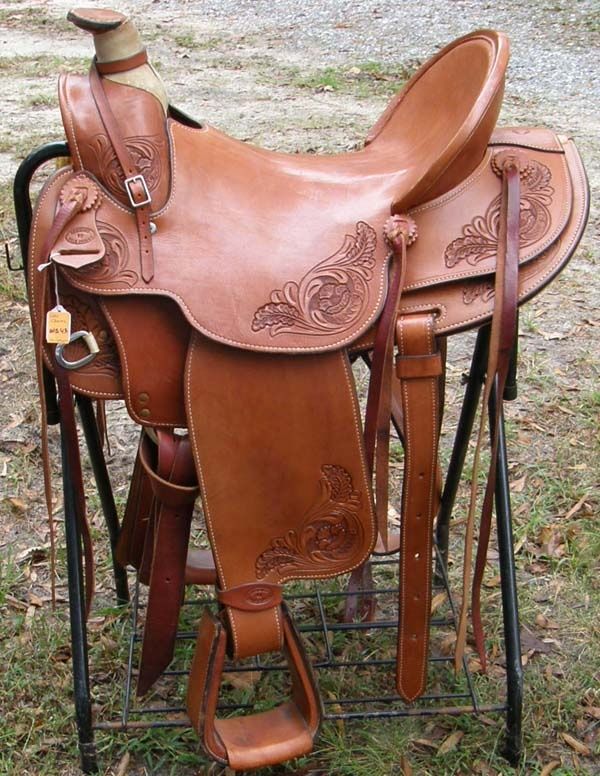 a brown saddle sitting on top of a metal stand